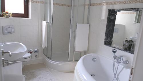 ein Bad mit einer Dusche, einem Waschbecken und einem WC in der Unterkunft Summerset Ferienwohnung in Rosengarten