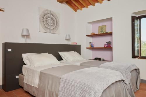 a bedroom with a large bed with two pillows at Grandono Agriturismo in Maremma in Scansano