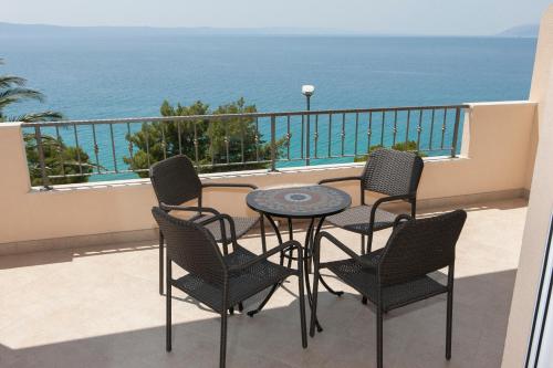 a balcony with a table and chairs and the ocean at Apartments Nevenka i Josko in Tučepi