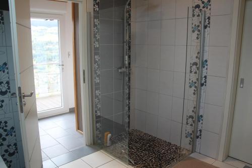 een douche met een glazen deur in een badkamer bij Chalet de la Rigue in La Bresse