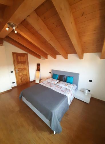 una camera con un grande letto in una stanza con soffitti in legno di FUSNAR a Aquilinia