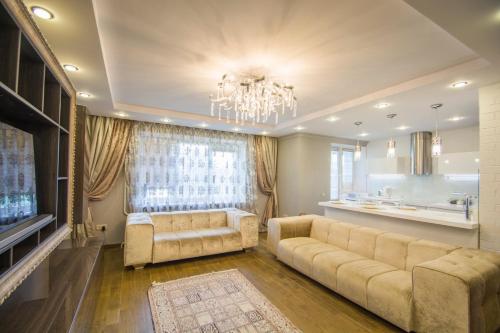 a living room with a large couch and a chandelier at Aparton in Minsk
