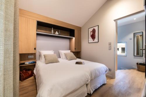 a bedroom with a large white bed in a room at Résidences Alticimes in Brides-les-Bains