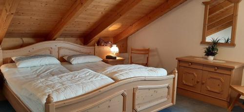 um quarto com uma grande cama branca num sótão em Joseph's am Bach em Übersee