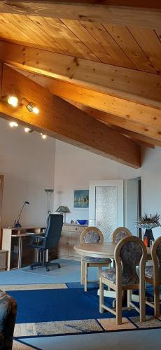 uma sala de estar com uma mesa e cadeiras e um tecto de madeira em Joseph's am Bach em Übersee