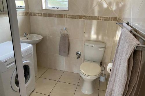 a small bathroom with a toilet and a sink at Uvongo Chalets 12 in Margate