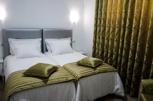 una camera con un letto con due cuscini sopra di AQUACHAVES - Apart Studios a Chaves