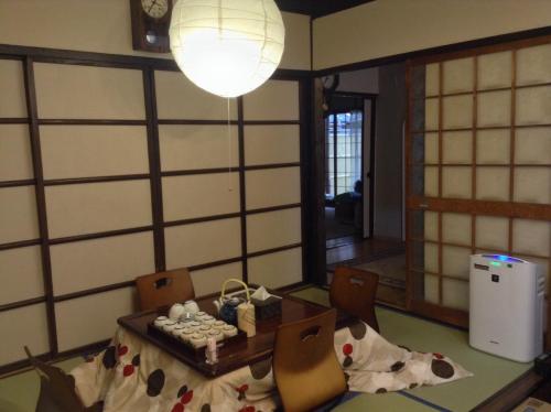 a room with a table and chairs and a lamp at Machiya Kyoto Shogoin in Kyoto