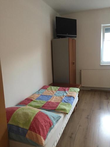 Un dormitorio con una cama con una manta de colores. en Sólyom Magánszállás, en Szombathely