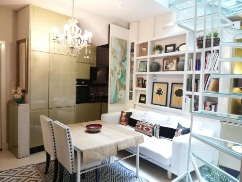 a dining room with a table and a couch at Duplex and terrace overlooking Giralda in Seville