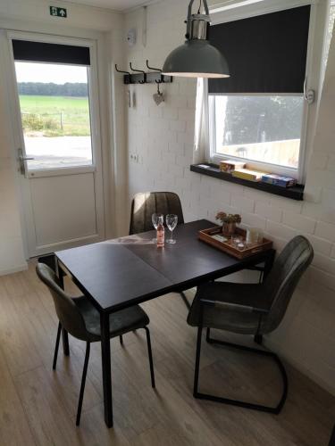a dining room table and chairs in a room at De Kuiperij in Arcen