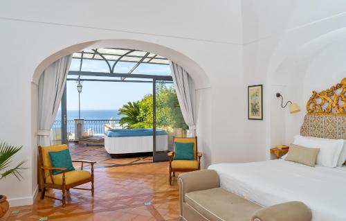 Schlafzimmer mit einem Bett und Meerblick in der Unterkunft Hotel Punta Regina in Positano