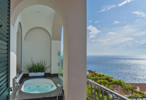 a white toilet sitting in front of a balcony overlooking the ocean at Hotel Punta Regina in Positano