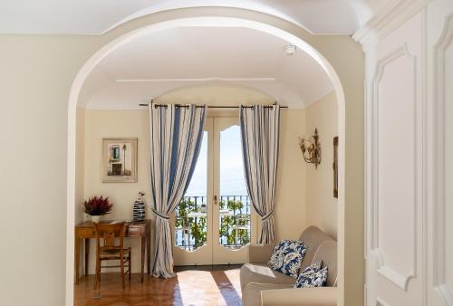 a living room filled with furniture and a window at Hotel Punta Regina in Positano