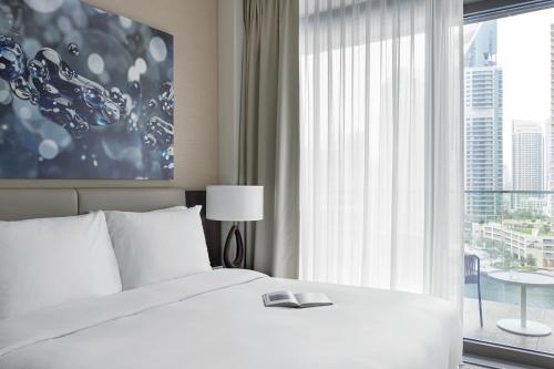 a bedroom with a white bed and a large window at Jumeirah Living Marina Gate Dubai in Dubai