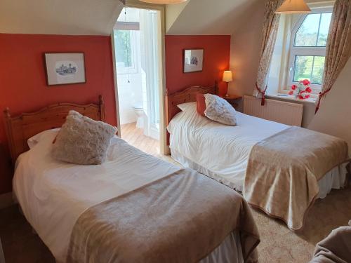 two beds in a room with red walls at The Goathland Hotel in Goathland