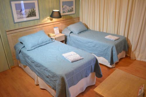 Habitación de hotel con 2 camas y mesa en Hotel Solar del Acuario, en Salto