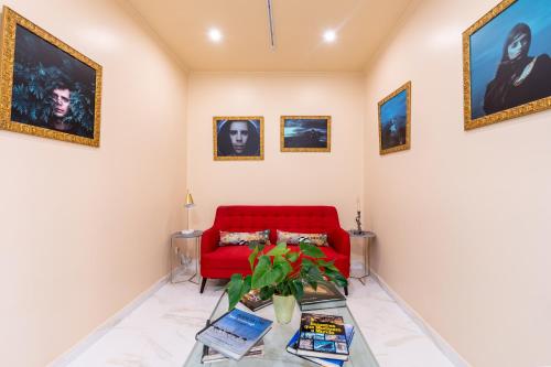 a living room with a red couch and pictures at Sé Boutique Hotel in Funchal