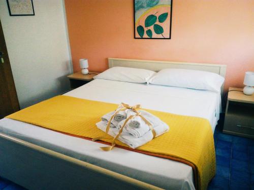 Una habitación de hotel con una cama con toallas. en Nido Colorato B&B, en Fontane Bianche