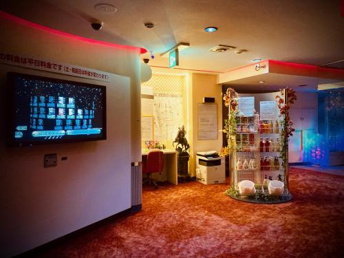 een kamer met een grote monitor aan de muur en een kamer met een kamer bij Hotel Sagano (Adult only) in Kyoto