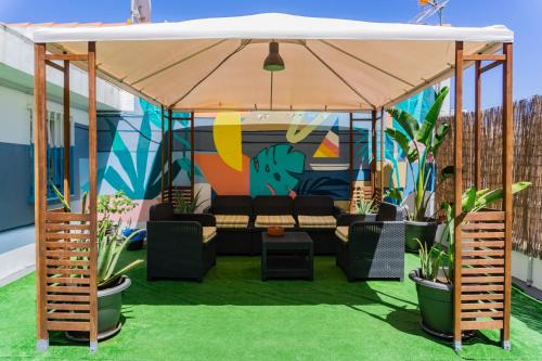 a gazebo with a couch and some plants at Tenerife Experience Hostel in Santa Cruz de Tenerife