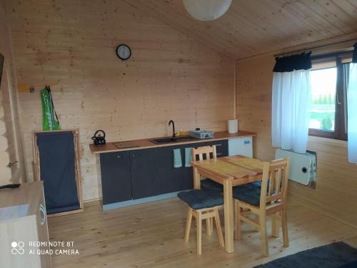 a kitchen with a table and chairs in a cabin at Witówka in Bieliny