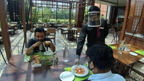a man sitting at a table with a man wearing a virtual reality at The Orchid Hotel Hinjewadi Pune in Pune