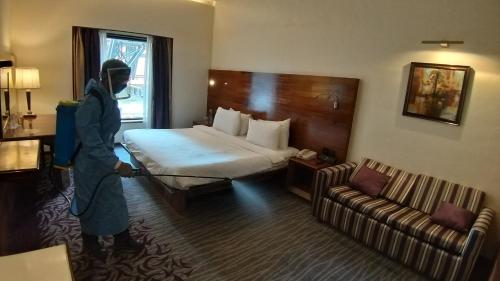 a person wearing a mask in a hotel room at The Orchid Hotel Hinjewadi Pune in Pune