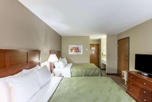 a hotel room with two beds and a flat screen tv at Quality Inn in Athens