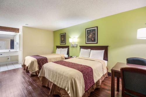 Bolivar的住宿－Rodeway Inn，酒店客房设有两张床和一张桌子。
