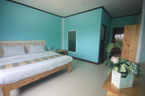 a bedroom with a bed and a blue wall at Au Hotel in Phra Nakhon Si Ayutthaya