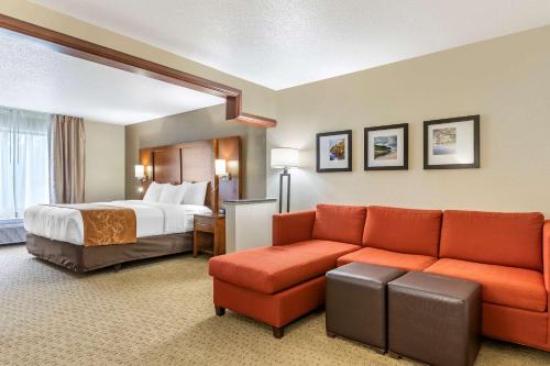 a hotel room with a bed and a couch at Comfort Suites Grand Rapids North in Comstock Park