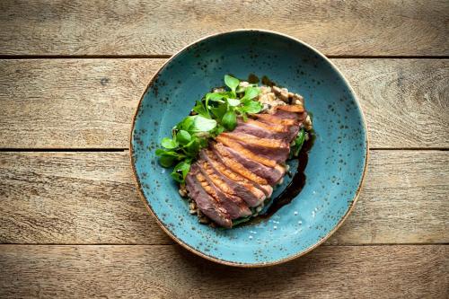 a blue plate with a piece of steak on a table at Kimpton Hotel Monaco Philadelphia by IHG in Philadelphia