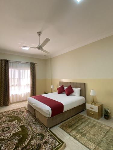 a bedroom with a large bed and a window at Sama Sohar Hotel Apartments - سما صحار للشقق الفندقية in Sohar