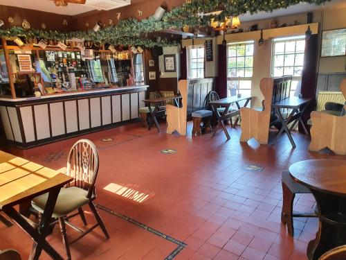 un restaurante con mesas y sillas y un bar en The Goathland Hotel en Goathland