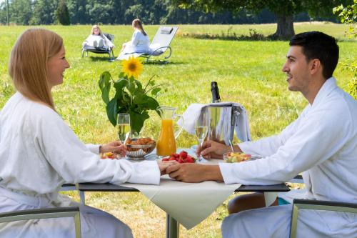 a man and woman sitting at a table with food at Wellnesshotel Sonnenhof & Sonnhalde in Ühlingen-Birkendorf