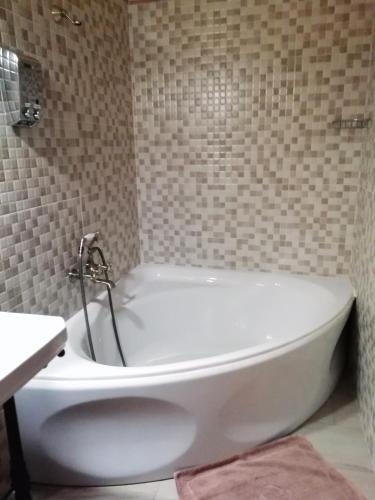 Hostal Rural Mas Blanc في San Martín de Centellas: حوض استحمام أبيض في حمام مع حوض
