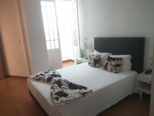 a bedroom with a large white bed with blankets and pillows at Hotel Paulista in Porto