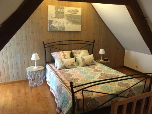 a bedroom with a bed and two lamps in a attic at L Ecrin, duplex classé 2 étoiles, au cœur de Villandry in Villandry