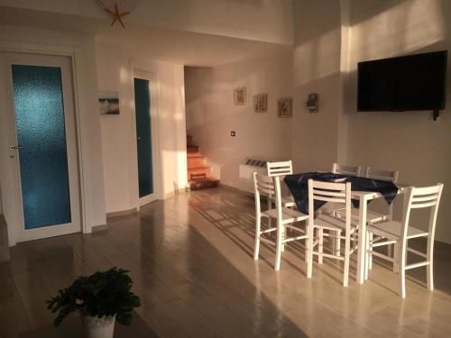 comedor con mesa y sillas blancas en Casa Caterina Deluxe Sorrento Coast, en Meta