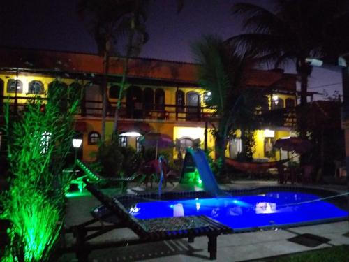 a resort with a slide and a swimming pool at night at Pousada Antåpriss in Angra dos Reis
