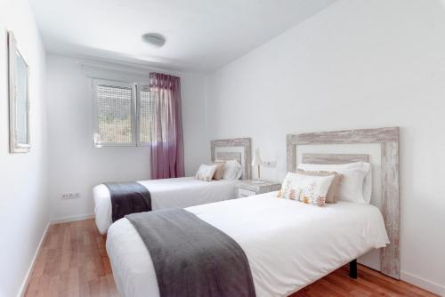 two beds in a room with white walls at Casco Antiguo 1 Altea17 by Vero in Altea