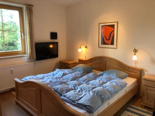 a large bed in a bedroom with a television at Filzsteinalpe Hochkrimml in Krimml