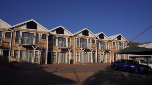 a row of houses with a car parked in front at The Royal Courtyard in Matatiele
