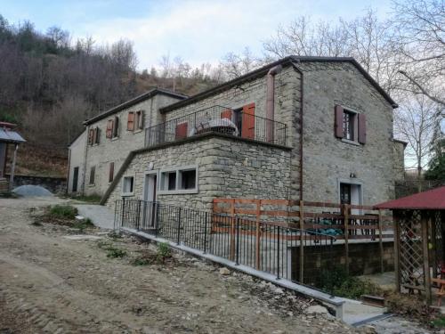 an old stone house with a fence in front of it at Agriturismo Coradosso "Il Fienile" in Selvapiana