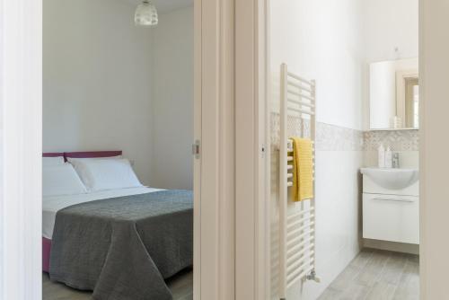 a bedroom with a bed and a bathroom with a sink at Villetta Silvana by Wonderful Italy in Ostuni