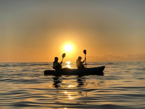 three people in a canoe on the water at sunset at Villas del Santo Niño in Loreto