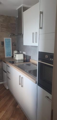 a kitchen with white cabinets and a stove top oven at 3 Braehead in Thurso
