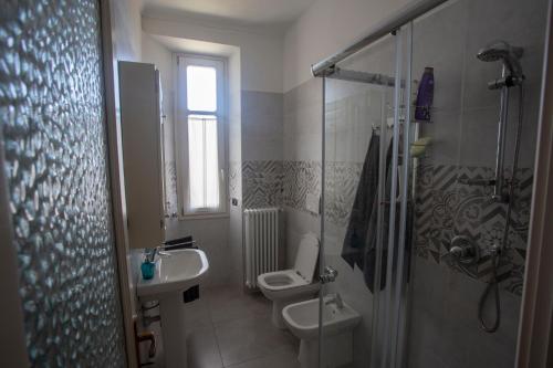 a bathroom with a toilet and a sink and a shower at Appartamento con vista a Torre Pellice in Torre Pellice