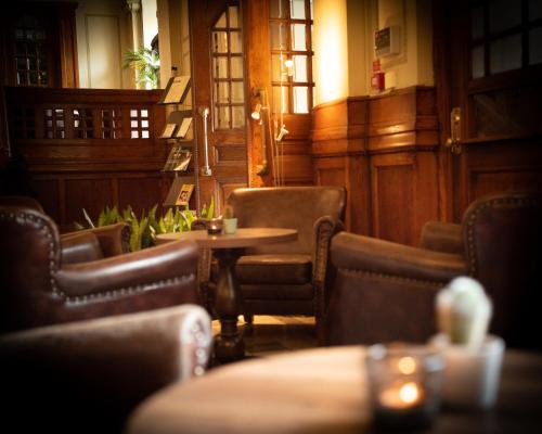 a restaurant with chairs and a table in a room at Stadshotellet Kristianstad in Kristianstad